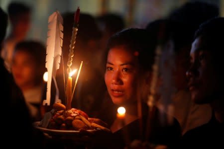 People hold offerings while praying for loved ones who have passed away during the first day of Pchum Ben festival, or the festival of the dead in Phnom Penh, Cambodia, September 25, 2018. REUTERS/Samrang Pring