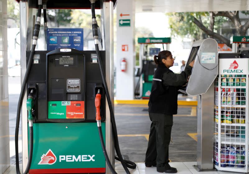 FILE PHOTO: Employee makes a payment next to fuel pumps at a Pemex gas station in Mexico City