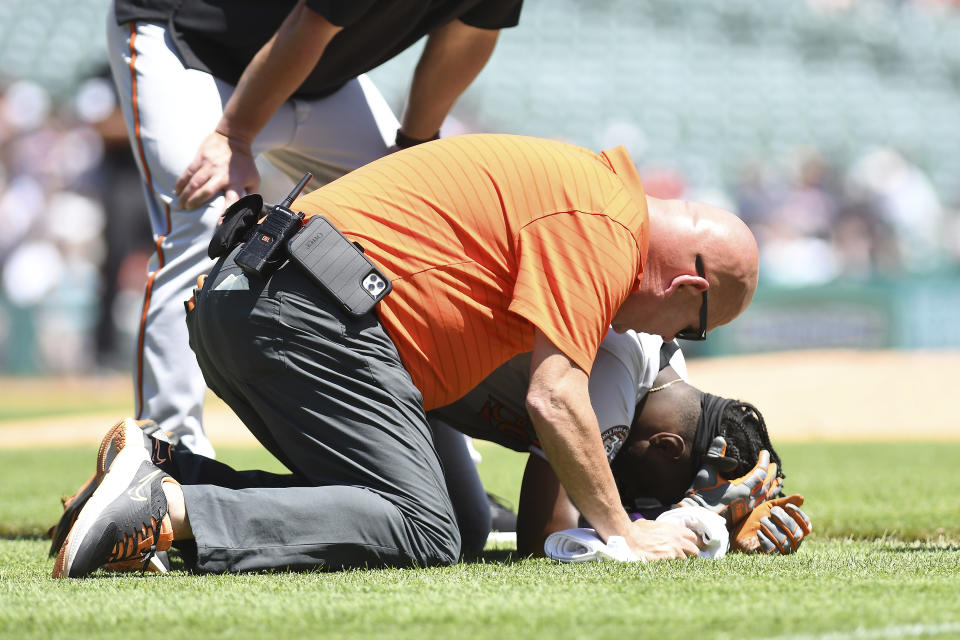 CORRECTS TO FIRST BASEMAN SPENCER TORKELSON NOT PITCHER TARIK SKUBAL - Baltimore Orioles' Jorge Mateo, bottom, is tended to by the team trainer after being injured in a collision with Detroit Tigers first baseman Spencer Torkelson in the second inning of a baseball game in Detroit, Sunday, May 15, 2022. (AP Photo/Lon Horwedel)