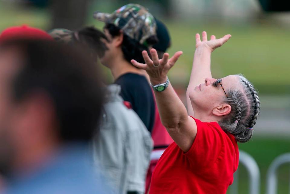 A Mike Pence and Donald Trump supporter prays before the start of a campaign rally near the Cuban Memorial Monument in Tamiami Park on Thursday, Oct. 15, 2020 in Miami, Florida.