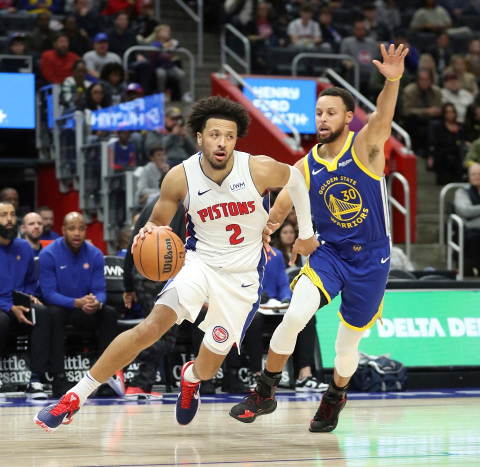 Detroit Pistons guard Cade Cunningham (2) drives against Golden State Warriors guard Stephen Curry (30) during fourth-quarter action at Little Caesars Arena in Detroit on Monday, Nov. 6, 2023.