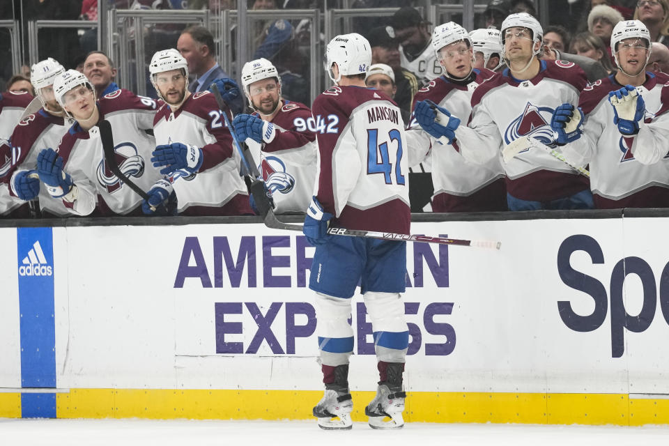 Colorado Avalanche defenseman Josh Manson (42) celebrates with teammates after scoring during the first period of an NHL hockey game against the Los Angeles Kings Sunday, Dec. 3, 2023, in Los Angeles. (AP Photo/Ashley Landis)