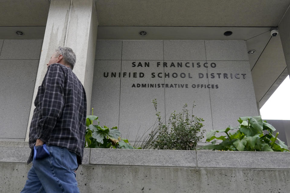 A pedestrian walks past a San Francisco Unified School District office building in San Francisco, Thursday, Feb. 3, 2022. A seemingly endless amount of drama, name-calling, lawsuits _ and outrage from parents and city officials _ made the saga of San Francisco's school board a riveting pandemic sideshow that is about to play out at the ballot box. (AP Photo/Jeff Chiu)