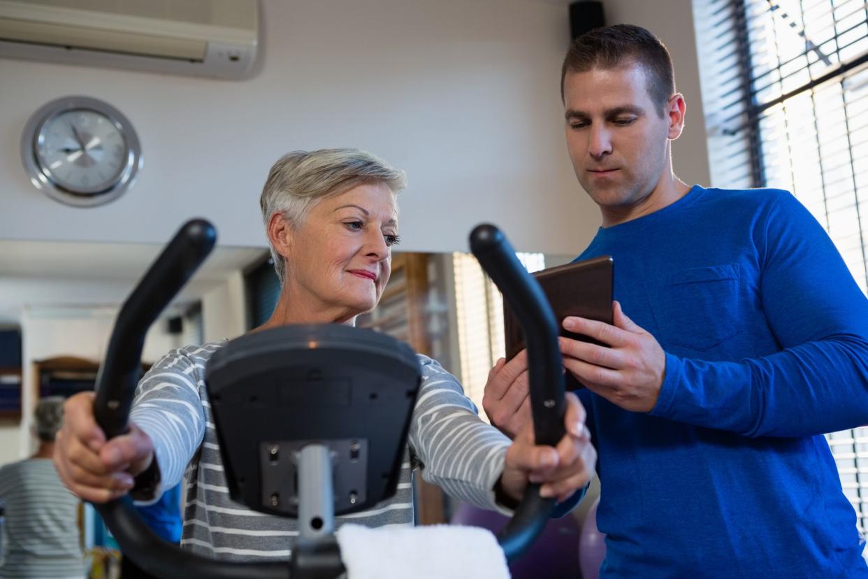 Physiotherapist showing record on digital tablet in clinic