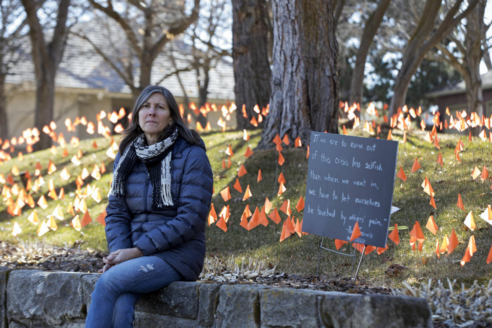 CORRECTS SPELLING OF LAST NAME ON FIRST REFERENCE - Cindy Pollock poses for a portrait in Boise, Idaho, on Wednesday, Feb. 10, 2021. Pollock began planting the tiny flags across her yard — one for each of the more than 1,800 Idahoans killed by COVID-19 — the toll was mostly a number. Until two women she had never met rang her doorbell in tears, seeking a place to mourn the husband and father they had just lost. (AP Photo/Otto Kitsinger)