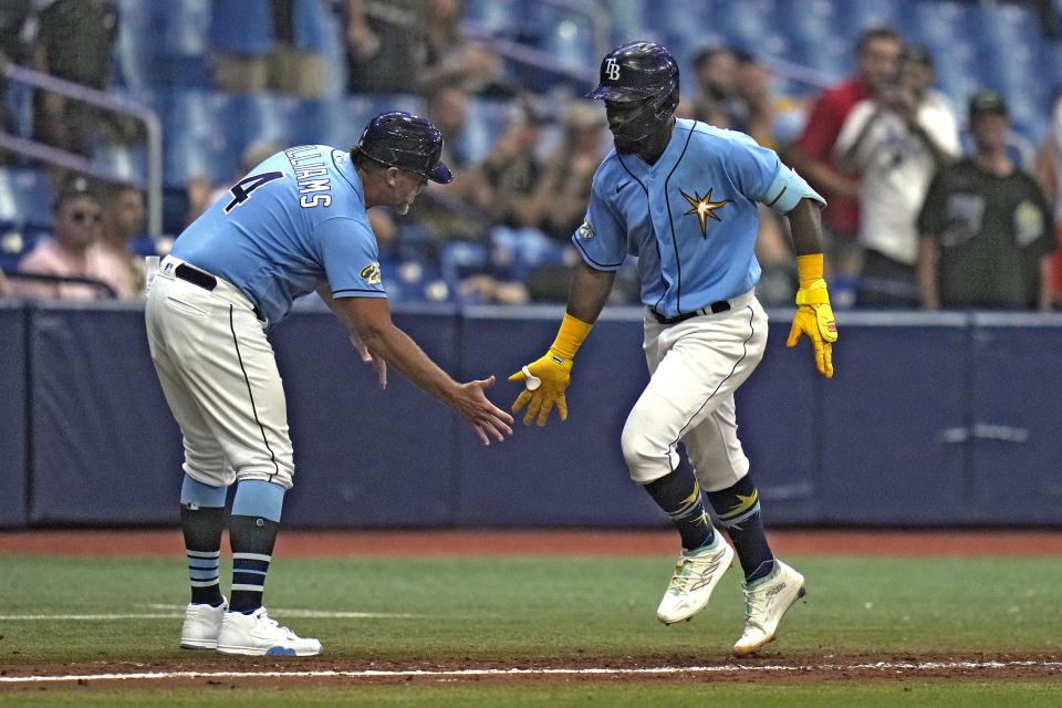 Tampa Bay Rays' Osleivis Basabe, right, celebrates with third base coach Brady Williams (4) after hitting a grand slam off Colorado Rockies relief pitcher Daniel Bard during the eighth inning of a baseball game Tuesday, Aug. 22, 2023, in St. Petersburg, Fla. (AP Photo/Chris O'Meara)