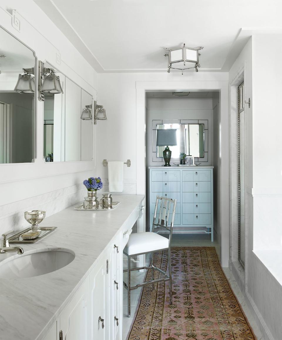 white bathroom with silver tone fixtures and old carpet