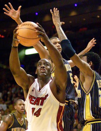 Miami Heat forward Anthony Mason (L) attempts to shoot around the defensive pressure of Indiana Pacers guard Jalen Rose (C) and forward Jonathan Bender (R) during the second quarter of NBA play in Miami, Florida in this file photo from February 6, 2001. REUTERS/Files