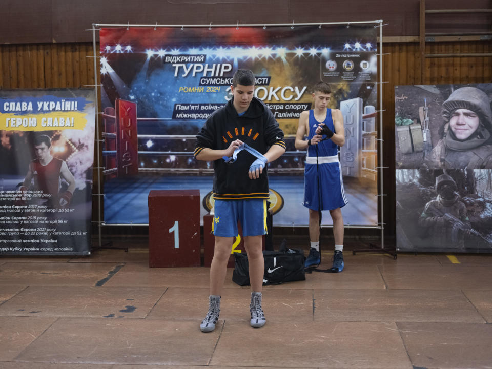 Young boxers prepare to fight during a boxing tournament in honor of Maksym Halinichev, who was killed during fighting with Russian forces in March 2023, in Romny, Sumy region, Ukraine on Saturday, Feb. 3, 2024. (AP Photo/Evgeniy Maloletka)