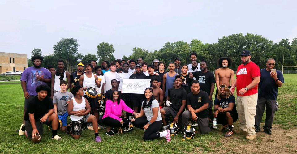 Akron native and New York Giants wide receiver Parris Campbell recently donated $5,000 to the North High School football team. New North coach DeMonte Powell holds a big check and poses for a photograph with his team.