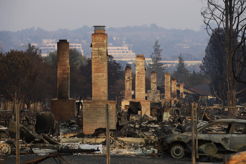 FILE - This Oct. 13, 2017 file photo shows a row of chimneys standing in a neighborhood devastated by the Tubbs fire near Santa Rosa, Calif. Investigators say the deadly 2017 wildfire that killed 22 people in California's wine country was caused by a private electrical system, not embattled Pacific Gas & Electric Co. The state's firefighting agency said Thursday, Jan. 24, 2019, that the Tubbs Fire started next to a residence. They did not find any violations of state law. (AP Photo/Jae C. Hong, File)