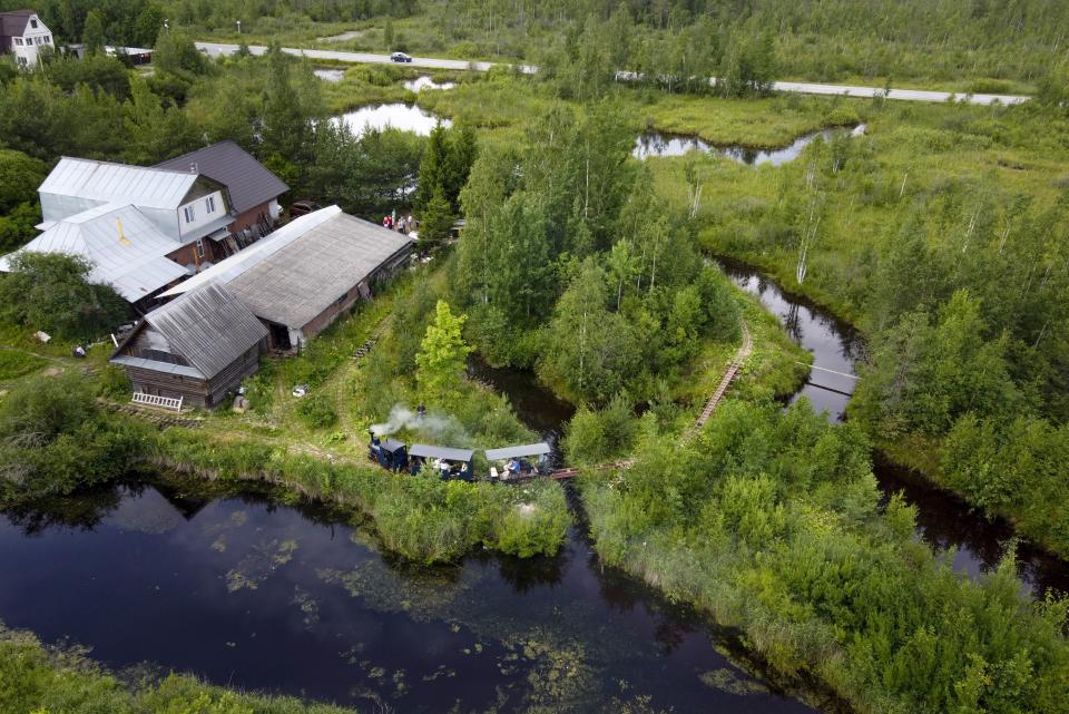 A miniature steam train travels along Pavel Chilin's miniature personal narrow-gauge railway twisting through the grounds of his home in Ulyanovka village outside St. Petersburg, Russia Sunday, July 19, 2020. It took Chilin more than 10 years to build the 350-meter-long mini-railway complete with various branches, dead ends, circuit loops, and even three bridges.(AP Photo/Dmitri Lovetsky)