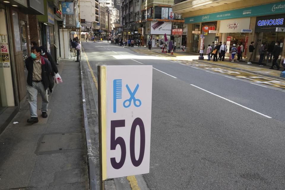 A haircut sign is seen outside a salon at a street after temporarily closing in Hong Kong, Thursday, March 10, 2022. (AP Photo/Vincent Yu)