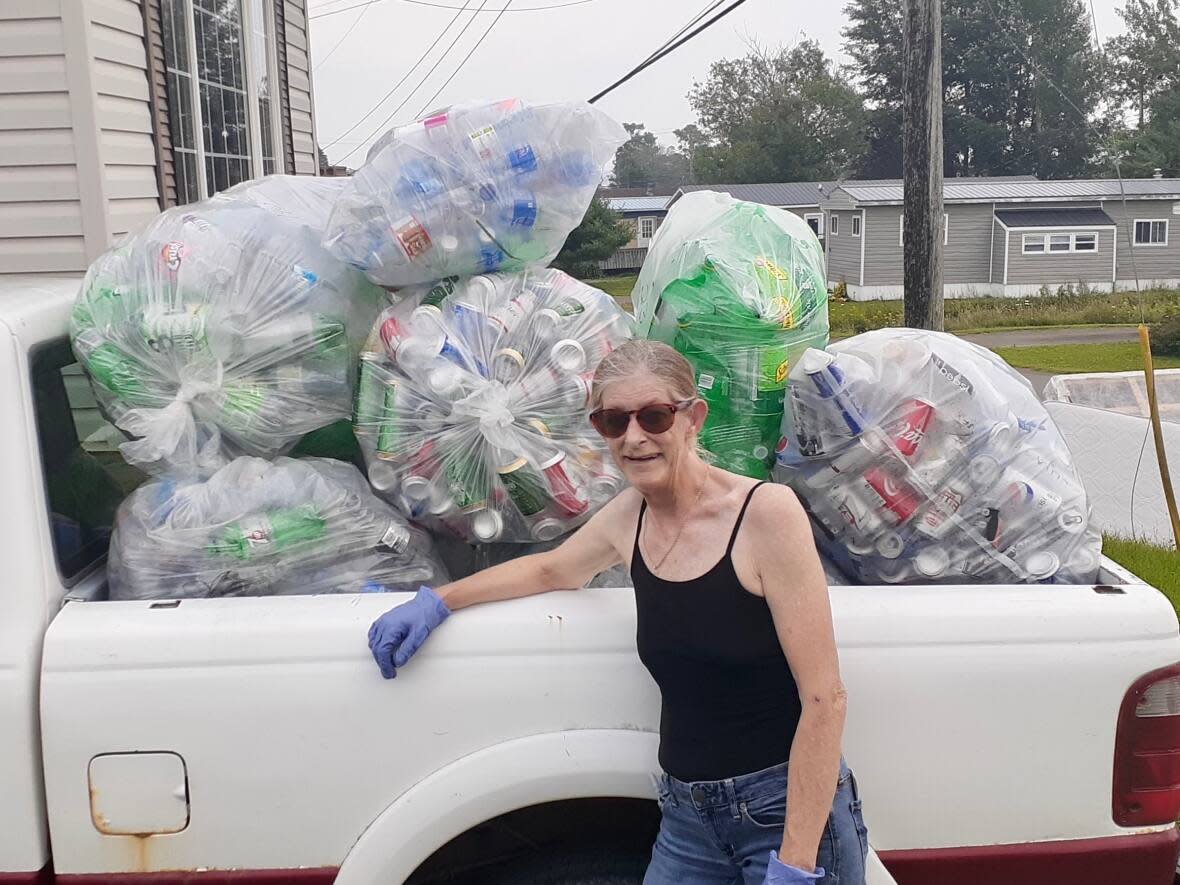 Tina Watkins stands with a load of recyclables she collected to fund her new roof. (Submitted by Tina Watkins - image credit)