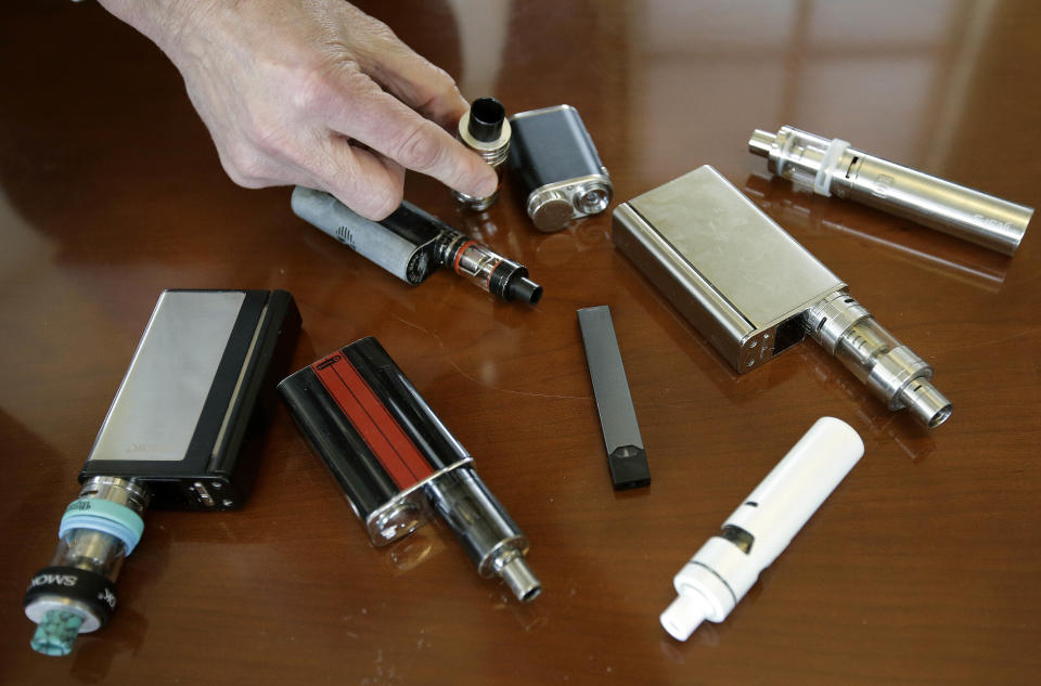 FILE - In this Tuesday, April 10, 2018 file photo, Marshfield High School Principal Robert Keuther displays vaping devices that were confiscated from students in such places as restrooms or hallways at the school in Marshfield, Mass. Massachusetts Gov. Charlie Baker is declaring a public health emergency and ordering a four-month temporary ban on all vaping products in the state. The Republican governor made the announcement Tuesday, Sept. 24, 2019, amid growing concern about the health effects of vaping products. (AP Photo/Steven Senne, File)