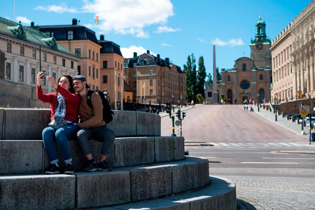 Tourists take a selfie outside the Royal palace in central Stockholm, Sweden