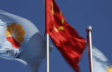 PetroChina's flag flutters next to the Chinese national flag at a gas station in Beijing in this August 29, 2013 file photo. REUTERS/Kim Kyung Hoon/Files