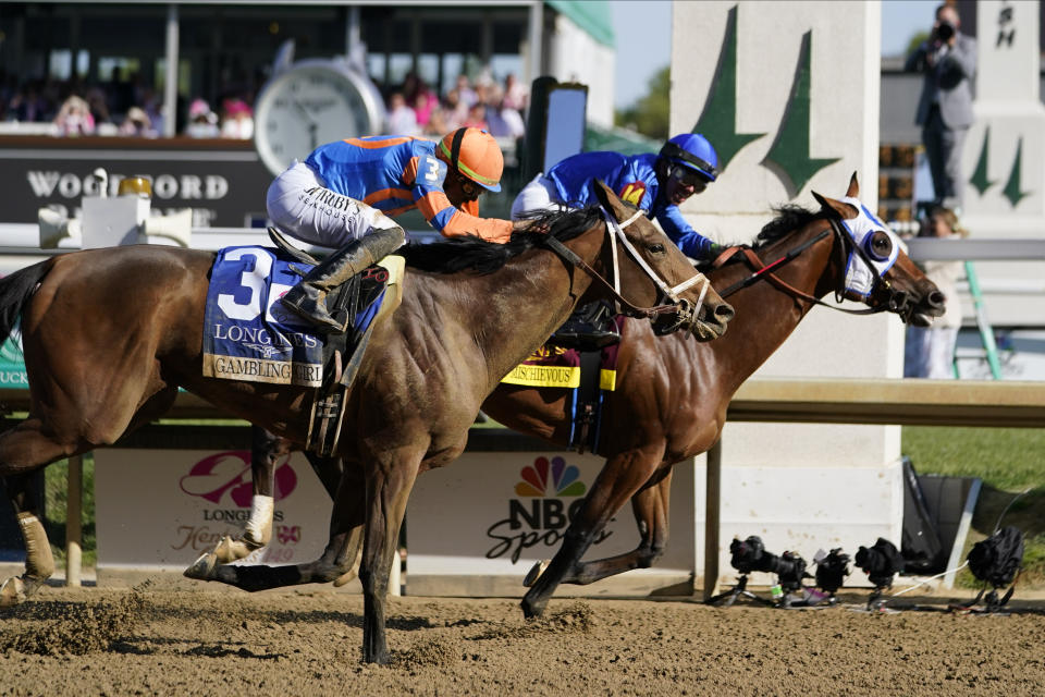 Pretty Mischievous (14), with Tyler Gaffalione aboard, past the finish line to win the 149th running of the Kentucky Oaks horse race at Churchill Downs Friday, May 5, 2023, in Louisville, Ky. (AP Photo/Kiichiro Sato)