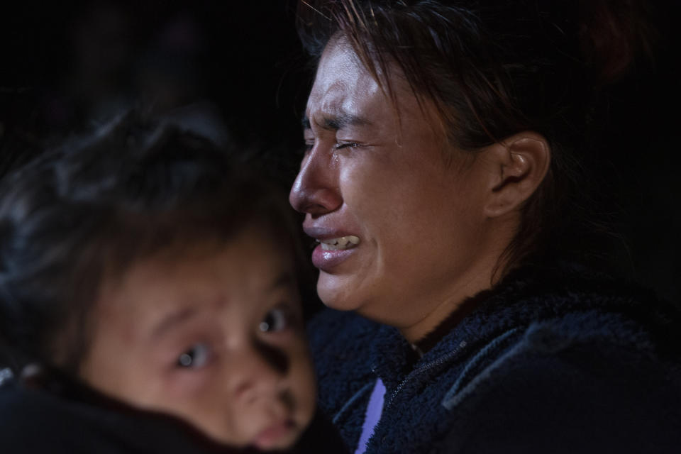 FILE - A woman from Guatemala weeps as she carries her child after being smuggled across the Rio Grande river in Roma, Texas, March 30, 2021. Biden took office on Jan. 20 and almost immediately, numbers of migrants exceeded expectations. (AP Photo/Dario Lopez-Mills, File)