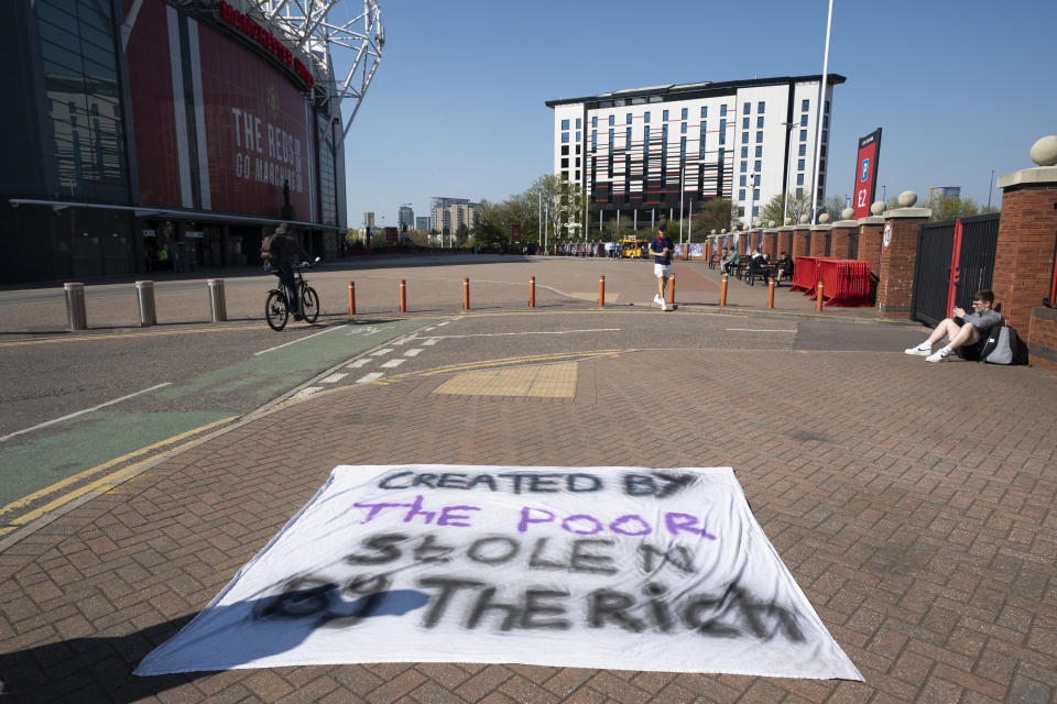 Football supporters place a protest banner outside Manchester United's Old Trafford Stadium, Manchester, England, Monday, April 19, 2021, opposing the formation of the European Super League. Players at the 12 clubs setting up their own Super League could be banned from this year’s European Championship and next year’s World Cup, UEFA President Aleksander Ceferin said Monday. (AP Photo/Jon Super)