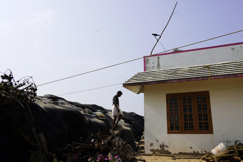 A man walks down a barrier built by residents along the shore out of sandbags in the Chellanam area of Kochi, Kerala state, India, March 4, 2023. After erosion destroyed an earlier sea wall, residents have been relying on the barrier. (AP Photo)