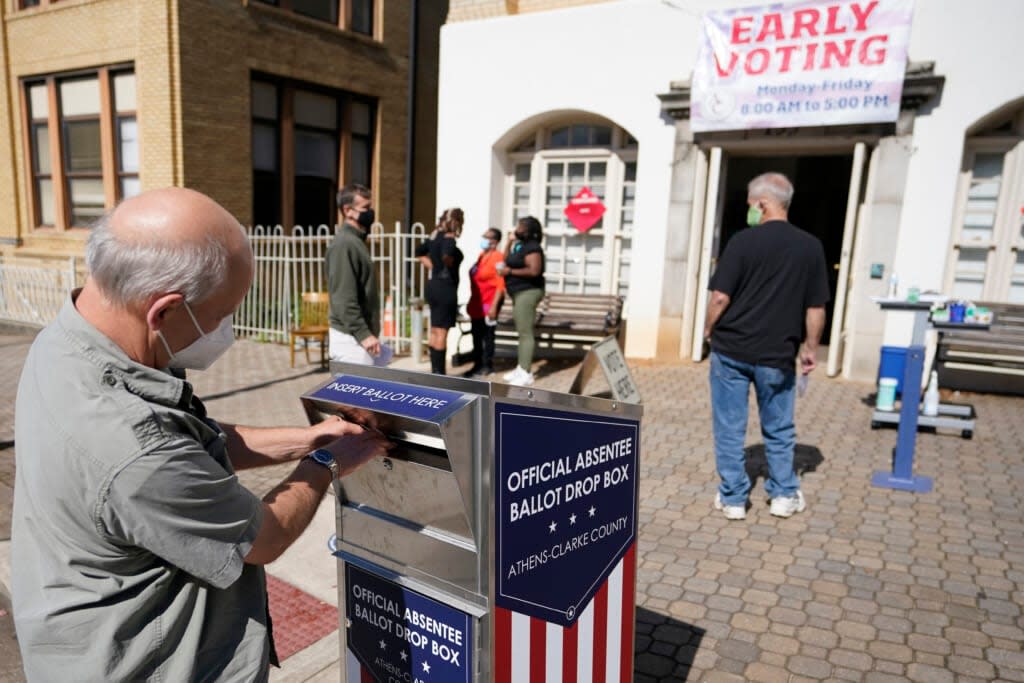 A voter submits a ballot in an official drop box during early voting in Athens, Ga., on Oct. 19, 2020. (AP Photo/John Bazemore, File)