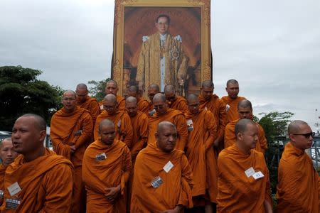 Buddhist monks stand next to a picture of Thailand's late King Bhumibol Adulyadej near the Grand Palace in Bangkok, Thailand January 11, 2017. REUTERS/Athit Perawongmetha