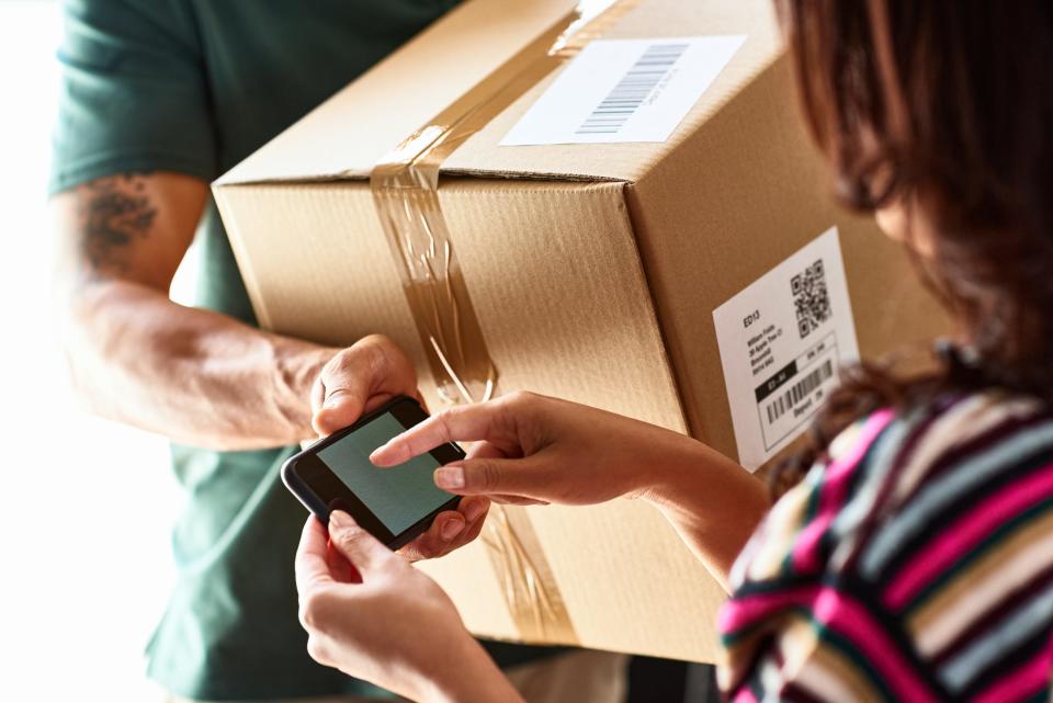 Customers signs for a parcel from delivery driver