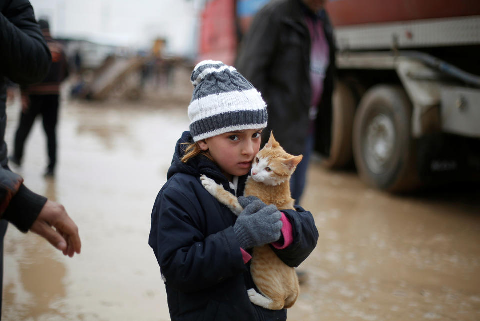 Malac holds her cat as she walks from Khazer camp