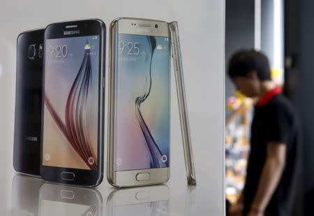 A man stands next to a banner promoting Samsung Electronics' smartphone Galaxy 6 at a store in Seoul, South Korea, July 7, 2015. REUTERS/Kim Hong-Ji