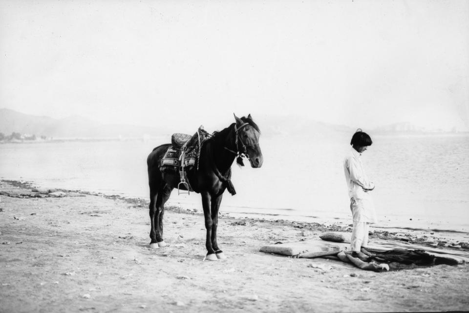 Kabir Jan, de 27 años, reza junto al lago Qargha el viernes 9 de junio de 2023, en las afueras de Kabul, Afganistán. Kabir, que alquila su caballo, de nombre Tajdar, a los turistas en el lago, gana el equivalente a 140 dólares al mes. (AP Foto/Rodrigo Abd)