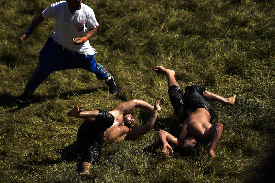 Wrestlers compete during the 663rd annual Historic Kirkpinar Oil Wrestling championship, in Edirne, northwestern Turkey, Saturday, July 6, 2024. Wrestlers take part in this "sudden death"-style traditional competition wearing only a pair of leather trousers and a good slick of olive oil. The festival is part of UNESCO's List of Intangible Cultural Heritages. (AP Photo/Khalil Hamra)