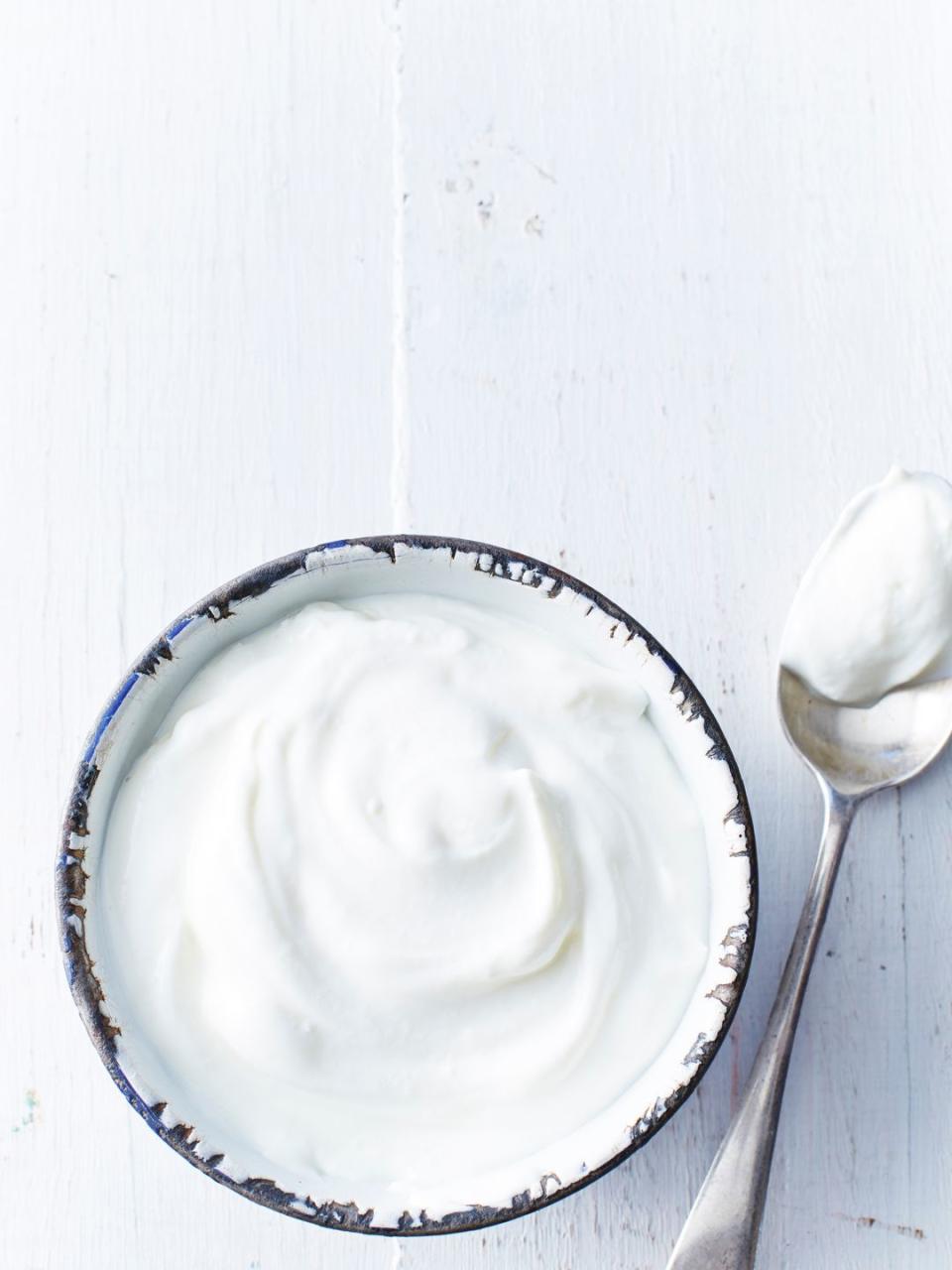 greek yogurt in a white bowl on a white wooden table