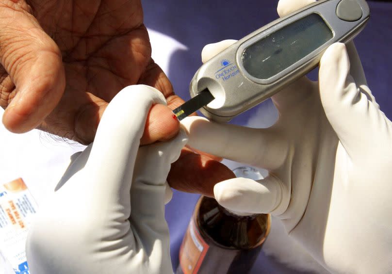 A nurse collects a blood sample from a patient during a free diabetes check-up camp in Hyderabad, November 2009