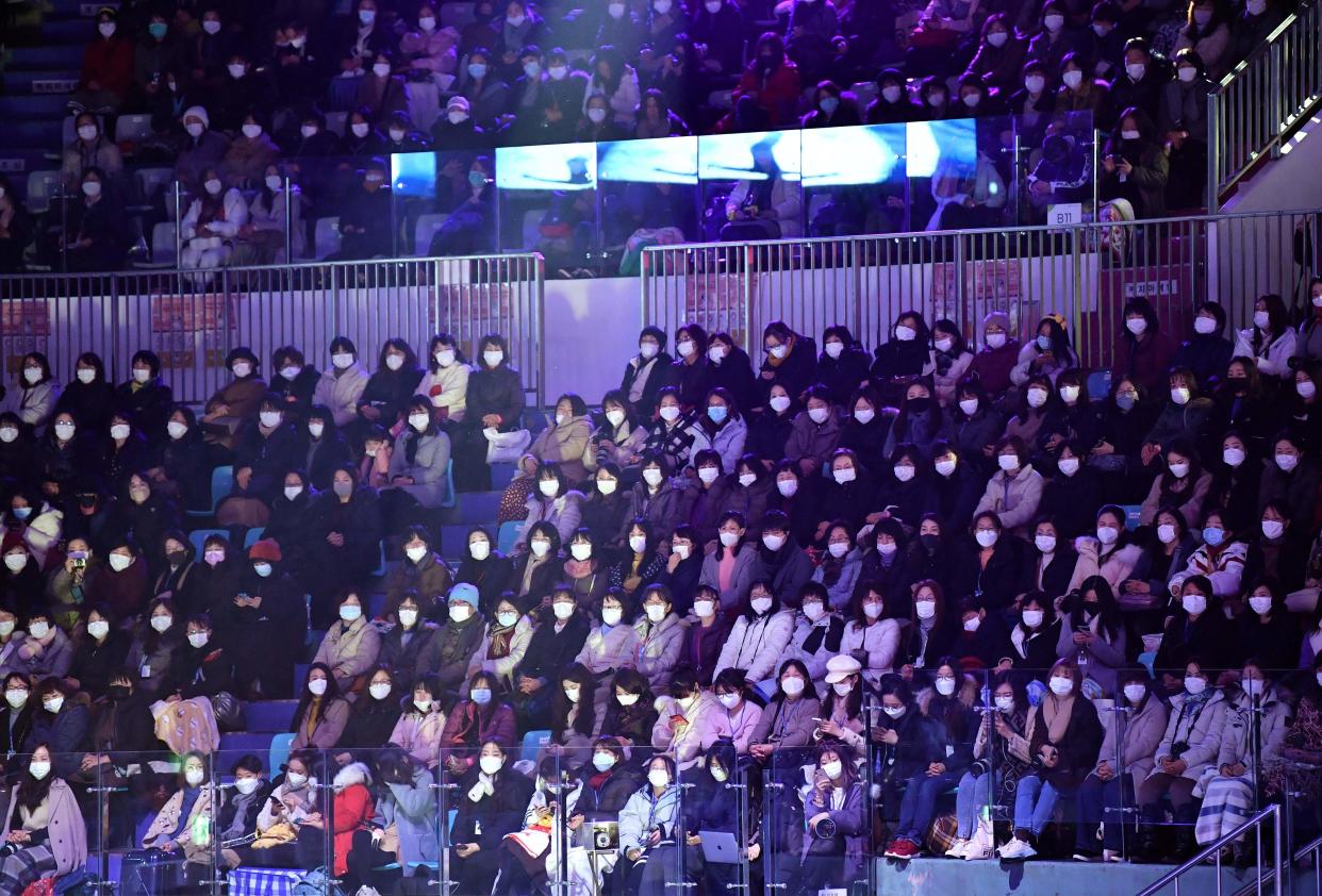 Espectadores de un espectáculo deportivo en Corea del Sur sentados en la grada, todos con máscara para evitar el contagio del coronavirus.