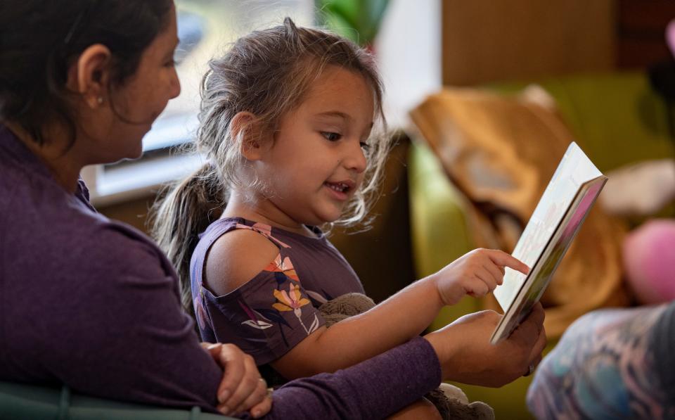 Cape Coral resident Karla Andersen reads to her daughter Kaydence, 3, during a visit to the new Art Cafe. "It is really cute. I like it a lot and it's kid-friendly," Andersen said.