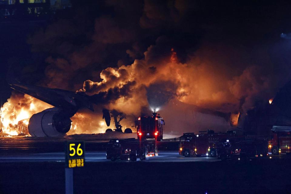 A Japan Airlines plane on fire on the runway of Haneda airport (AP)