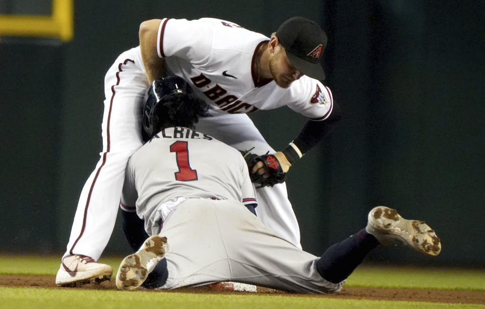 Atlanta Braves' Ozzie Albies (1) collides with Arizona Diamondbacks second baseman Josh VanMeter, top, during a steal-attempt in which he was out during the fifth inning of a baseball game Thursday, Sept 23, 2021, in Phoenix. (AP Photo/Darryl Webb)