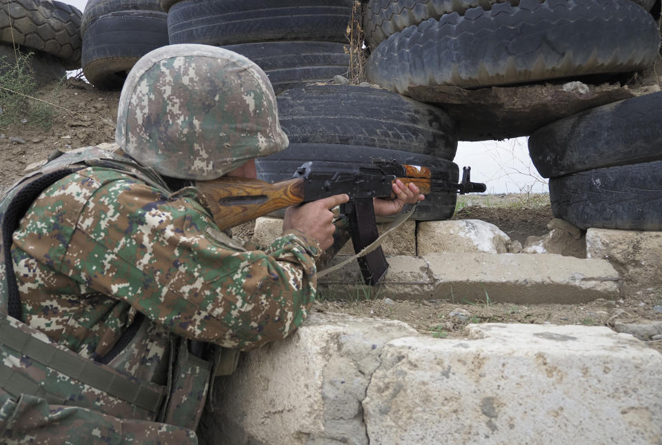 An Ethnic Armenian soldier holds a Kalashnikov machine gun as he looks toward Azerbaijan's positions from a dugout at a fighting position on the front line, during a military conflict against Azerbaijan's armed forces in the separatist region of Nagorno-Karabakh, Wednesday, Oct. 21, 2020. Armenia's prime minister has urged citizens to sign up as military volunteers to help defend the country amid the conflict with Azerbaijan over the disputed territory of Nagorno-Karabakh as intense fighting has raged for a fourth week with no sign of abating. (AP Photo)