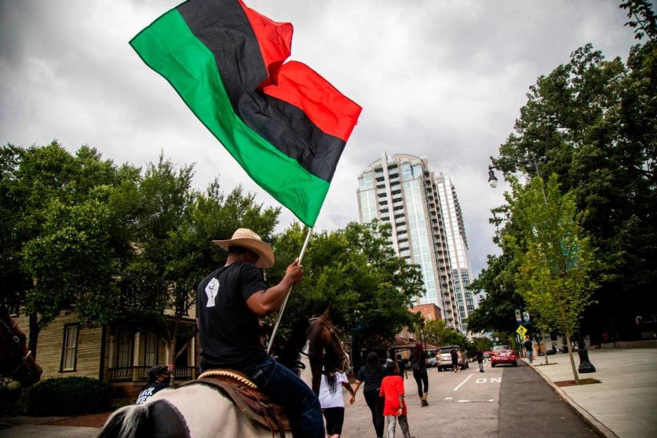 A Black Lives Matter demonstrator rides on horseback through downtown Raleigh Friday, June 19, 2020 in recognition of Juneteenth.