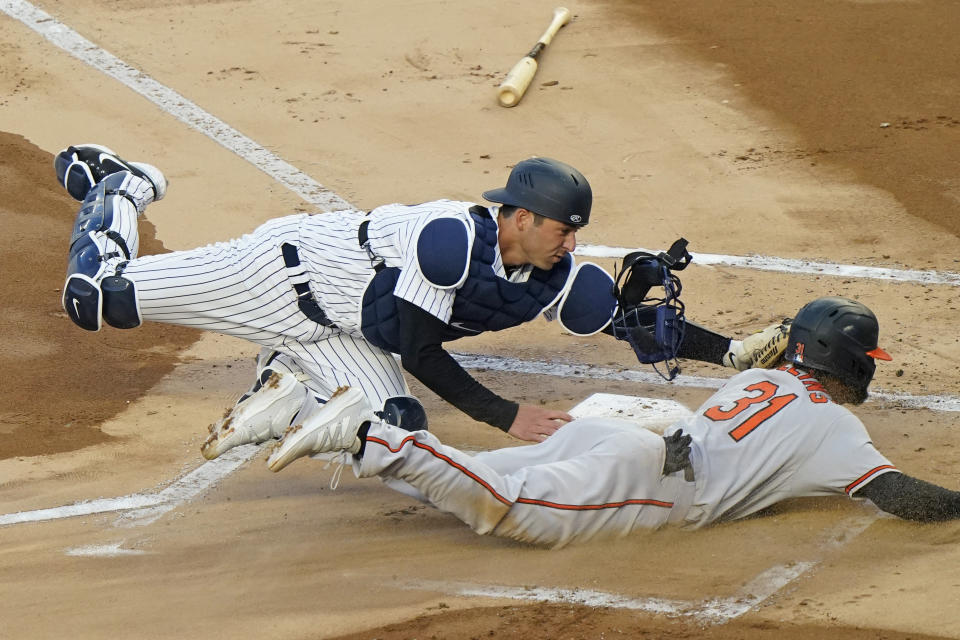 New York Yankees catcher Kyle Higashioka (66) tags Baltimore Orioles Cedric Mullins (31) out at the plate on a fielder's choice during the first inning of a baseball game, Tuesday, April 6, 2021, at Yankee Stadium in New York. Orioles Anthony Santander hit into the play. (AP Photo/Kathy Willens)