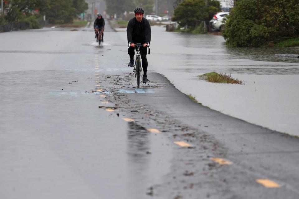 SAUSALITO, CALIFORNIA - JANUARY 07: Cyclists ride through a flooded bike path on January 07, 2023 in Sausalito, California. The San Francisco Bay Area continues to get drenched by powerful atmospheric river events that have brought high winds and flooding rains. The storms have toppled trees, flooded roads and cut power to tens of thousands. Storms are lined up over the Pacific Ocean and are expected to bring more rain and wind through next week. (Photo by Justin Sullivan/Getty Images)