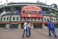 CORRECTS YEAR TO 2021-Los Angeles Dodgers fans Carlos Cativo and Nicole Ramos pose for a picture outside the Wrigley Field as a baseball game between the Chicago Cubs and Los Angels Dodgers has been postponed due to the forecast of inclement weather, Monday, May 3, 2021, in Chicago. (AP Photo/Kamil Krzaczynski)