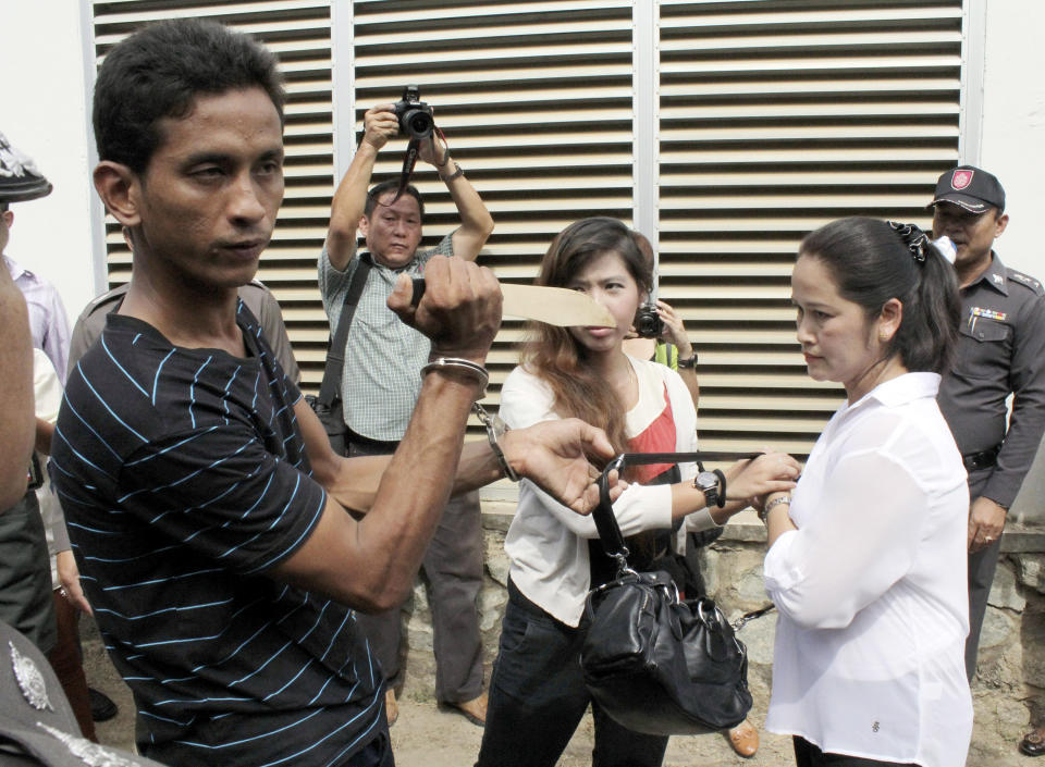 Thai suspect Surasak Suwannachote, 26, left, holds a mock knife as he is going to snatch a handbag from a woman during a police re-enactment in Phuket, southern Thailand Tuesday, June 26, 2012. Police arrested two Thai suspects in the slaying of an Australian woman who was stabbed to death when she resisted an attempt by two men on a motorcycle to snatch her bag on Thailand's resort island of Phuket. (AP Photo)