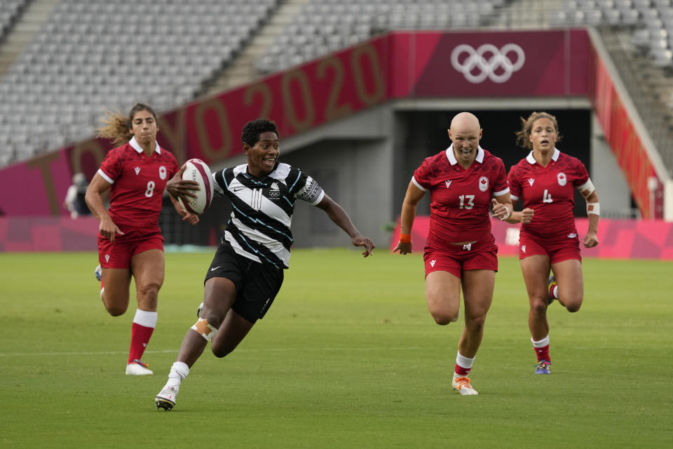 Fiji's Ana Maria Naimasi runs with the ball, pursued by Canada's Bianca Farella, left, Olivia Apps, second right, and Breanne Nicholas in their women's rugby sevens match at the 2020 Summer Olympics, Thursday, July 29, 2021 in Tokyo, Japan. (AP Photo/Shuji Kajiyama)