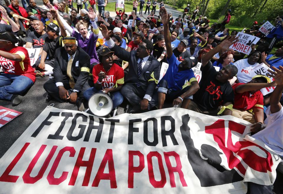 Demonstrators sit in the driveway during a protest at McDonald's headquarters in Oak Brook, Illinois, May 21, 2014. (REUTERS/Jim Young)