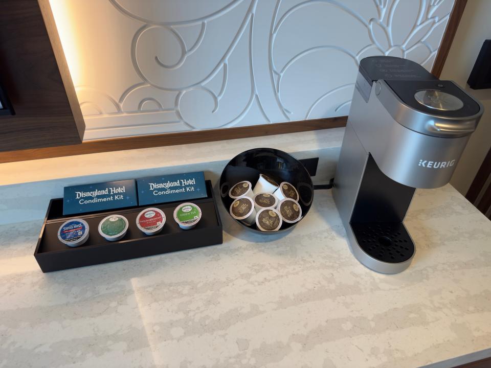 Single-cup Keurig machine next to bowl and tray of K-Cup pods in Disneyland duo studio
