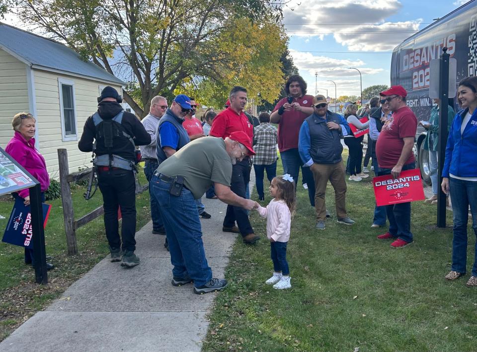 Three-year-old Mamie DeSantis, youngest daughter of Florida Gov. Ron DeSantis, shakes hands at an Iowa campaign stop.