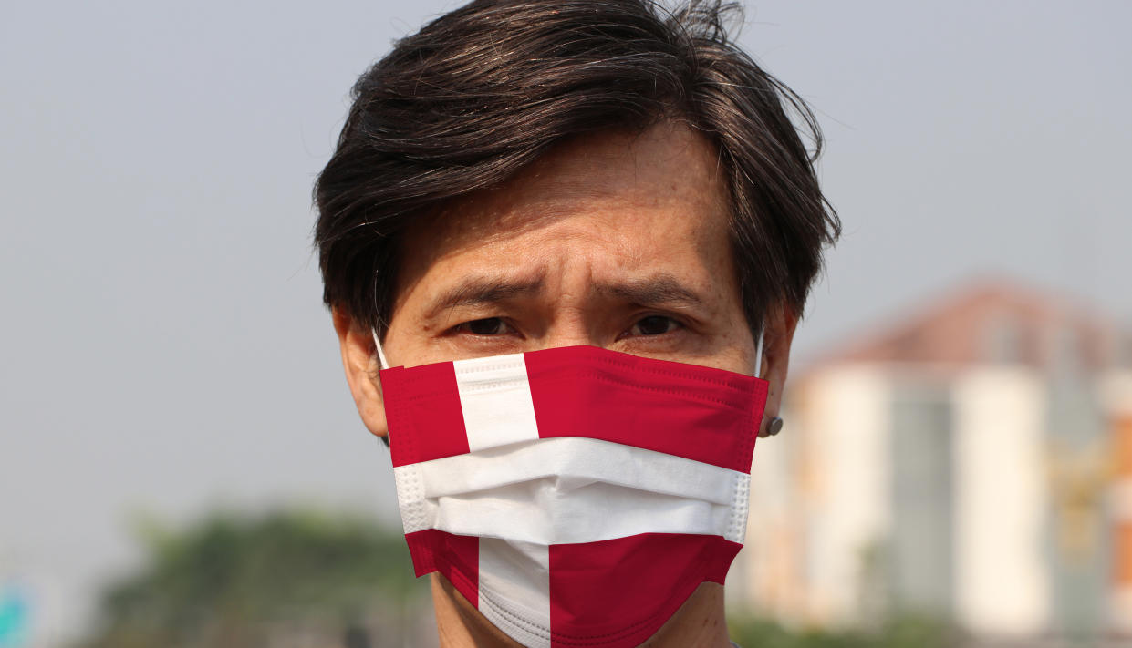 Denmark flag on hygienic mask. Masked the man prevent germs. Concept of Tiny Particle protection or virus corona or Covid19.