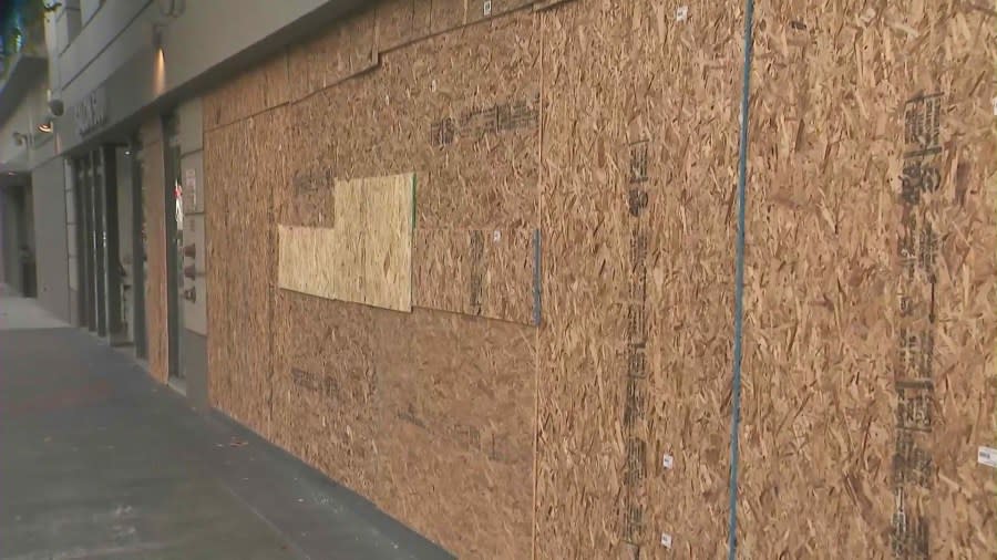 Shop windows were boarded up after a man went on a window-smashing spree in Long Beach's East Village neighborhood on June 6, 2024. (KTLA)